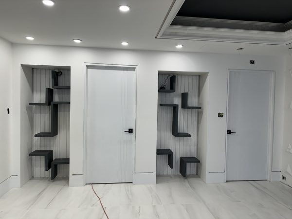 Custom built-in wall niches with modern floating shelves and recessed lighting by Delghavi Design & Build