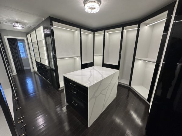 Luxury custom walk-in closet with built-in shelving, LED lighting, drawers, and quartz island by Delghavi Design & Build