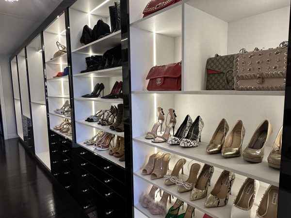 Custom walk-in closet with illuminated shelves displaying shoes and handbags, luxury cabinetry by Delghavi Design in King City