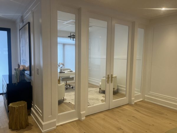Custom home office with glass double doors, white MDF wall paneling, gold hardware, and modern trim detailing — luxury interior renovation by Delghavi Design & Build in Aroura
