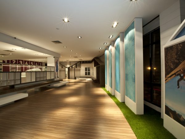 Custom commercial interior renovation featuring wood flooring, display walls, and architectural panels by Delghavi Design & Build