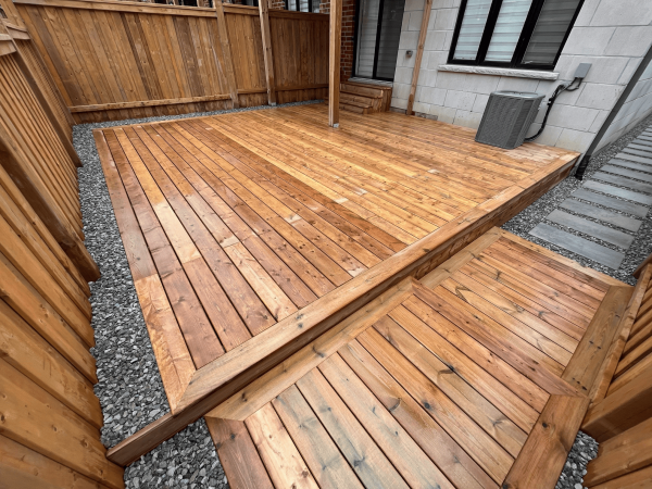 Custom backyard deck installation in Toronto with pressure-treated wood and step-down design