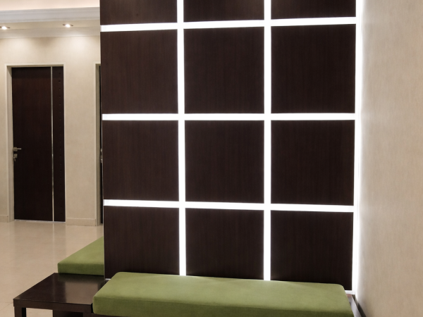 Custom illuminated wood panel feature wall with integrated LED lighting in a modern medical office renovation