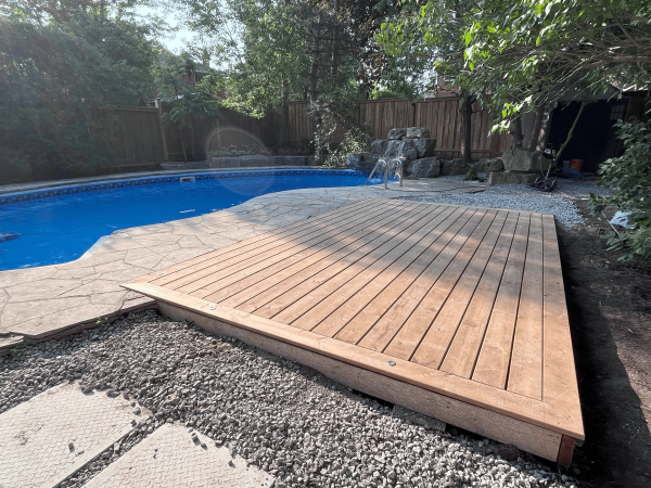 Custom wood poolside deck with stone patio in Aurora by Delghavi Design & Build in Aroura