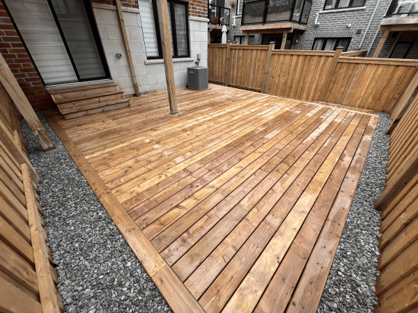 Custom pressure-treated wood deck with privacy fence by Delghavi Design & Build in Aurora