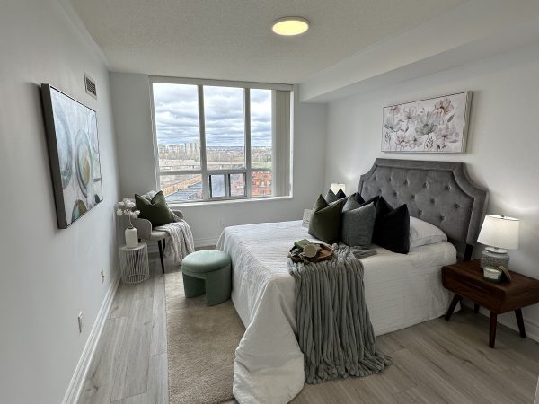 Open-concept condo living and dining area with floor-to-ceiling windows, modern furniture, and light wood flooring