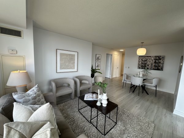 Modern open-concept living and dining room with neutral décor, light wood flooring, and contemporary furniture